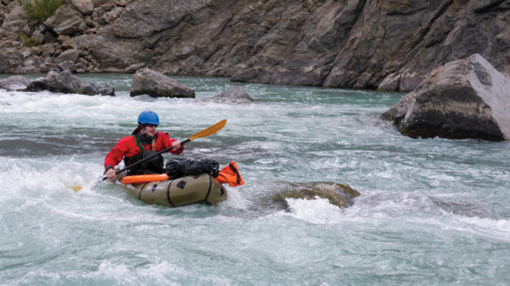 Ben paddles the Dambreak Rapids with rifle at the ready.